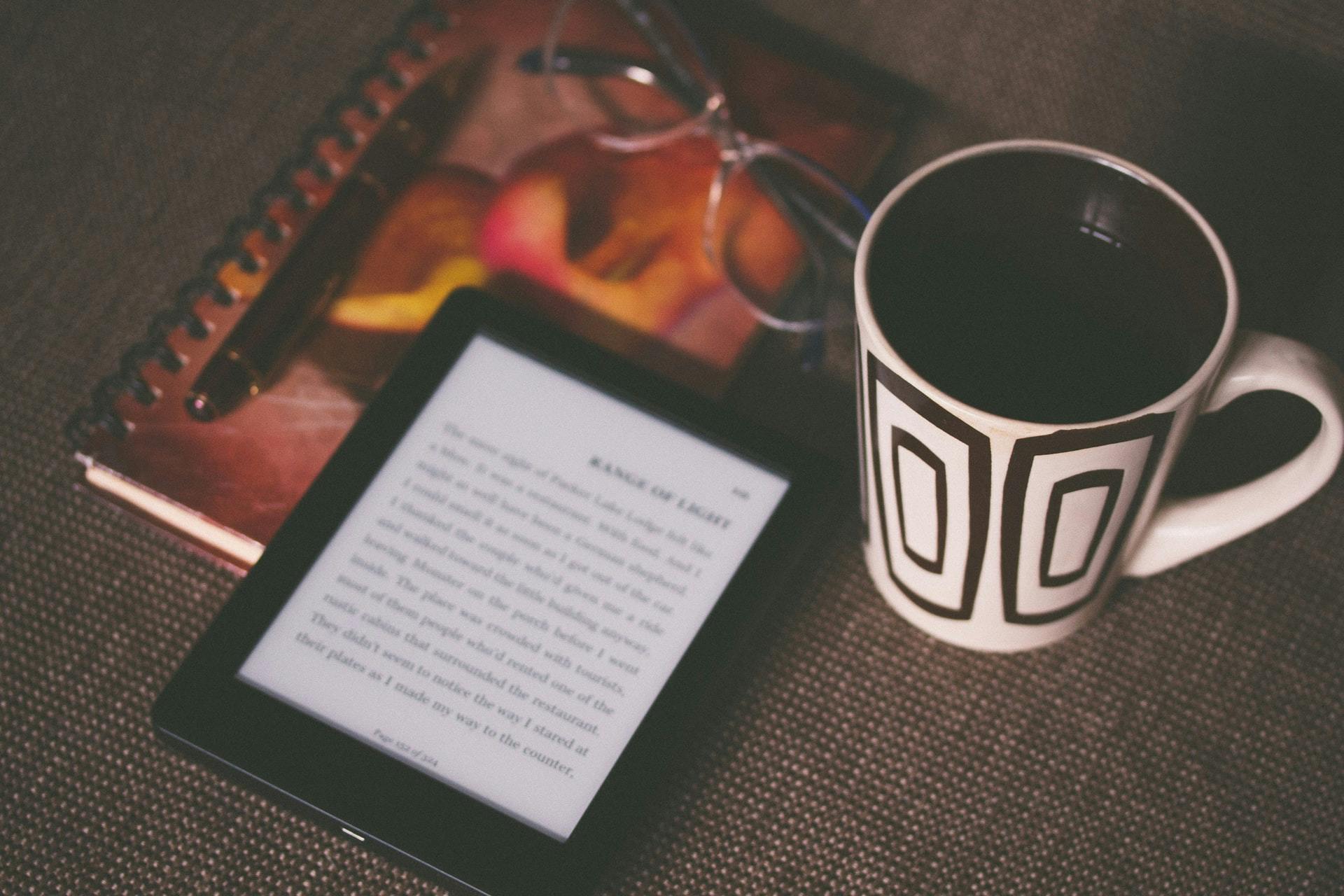 ebook reader mit tasse kaffe auf einem tisch