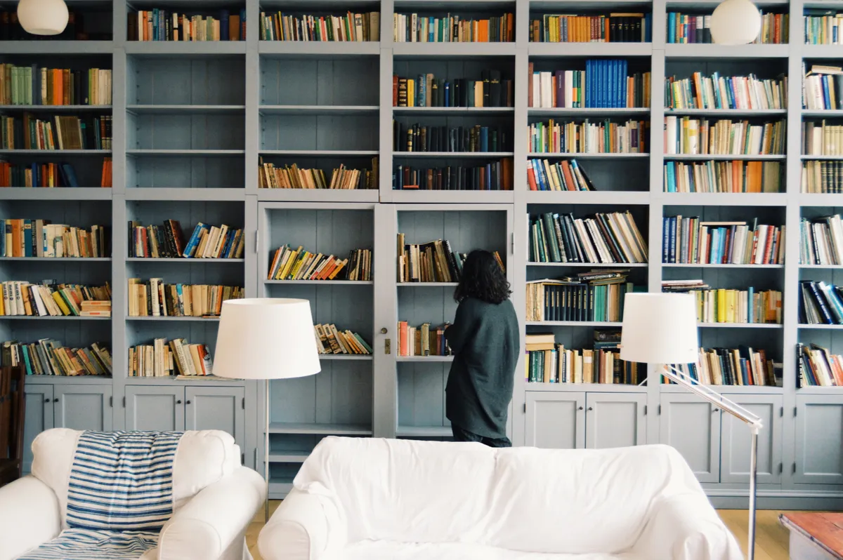 frau steht vor großem bücherregal
