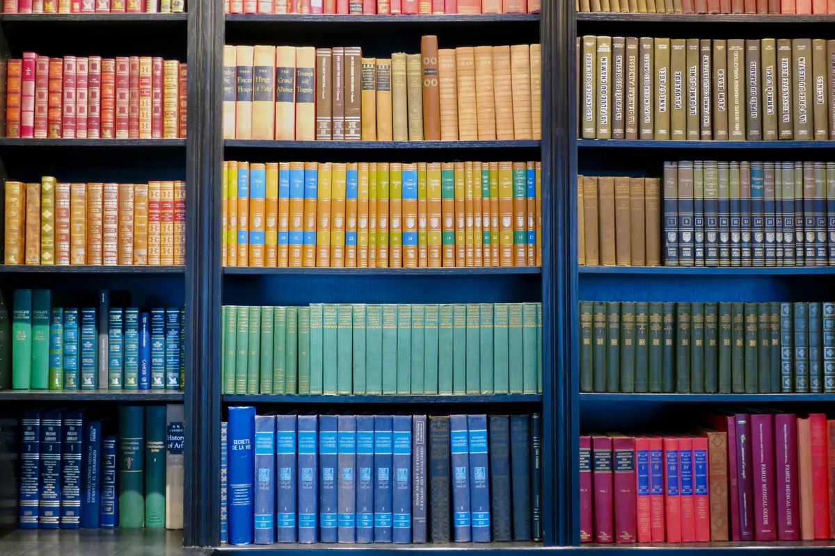 altes bücherregal mit farbig sortierten büchern