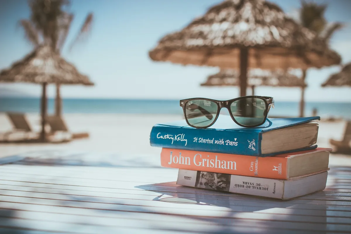gestappelte bücher am strand mit blick aufs meer